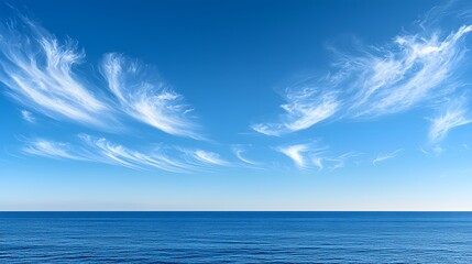 Obraz premium Blue sky filled with clouds above calm ocean waters