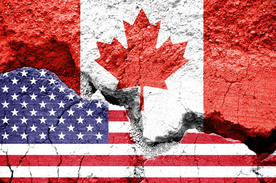 US American and Canadian flags on cracked background. Concept of  diplomatic crisis, tariffs and commercial trade war between United States and Canada