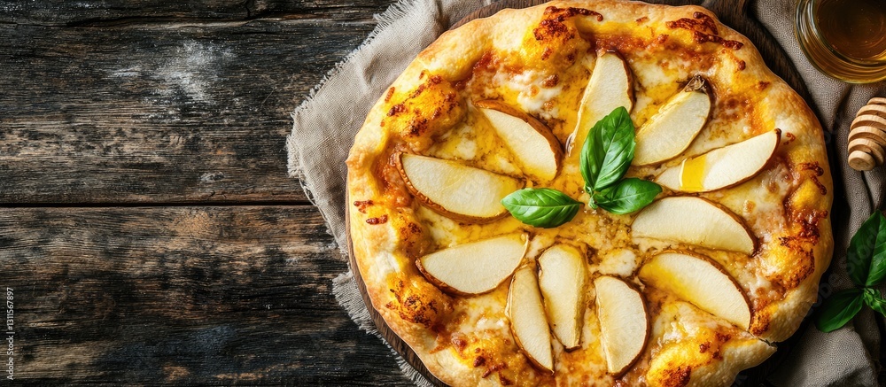 Poster rustic pear pizza topped with cheese and fresh basil arranged in a flower pattern against a dark woo