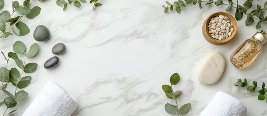 Serene spa arrangement with soft white towels herbal stones and green eucalyptus leaves on a light marble tabletop featuring ample space for text