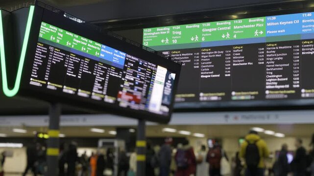 UK train station concourse.
Train station concourse showing information boards and passengers moving about.