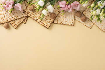 Matzo arranged with delicate pink and white flowers alongside walnuts on a beige surface