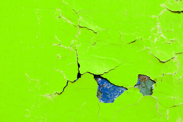 Texture background - bright green peeling paint on the old rough surface, green peeling paint...