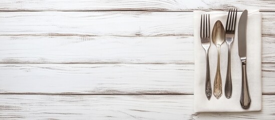 Elegant white wooden table with knife and fork placed on a light napkin at center left creating ample space for restaurant menu promotion