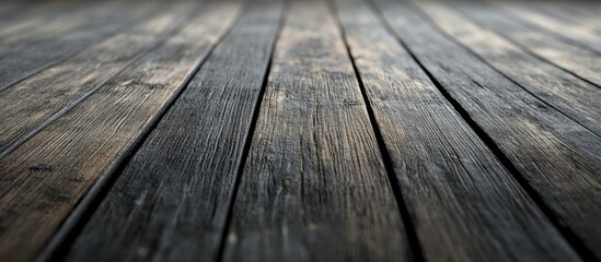 Obraz premium Weathered wooden floor texture in a dimly lit setting with dark tones and a blurred background, providing ample black and white copy space.