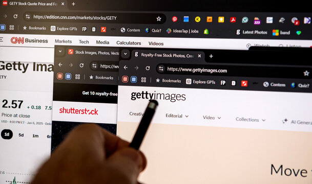 Frankfurt, Germany - Jan 22, 2025: A person browses stock photography websites, including Getty Images, Shutterstock, and CNN Business, comparing stock options, prices, and market trends online.