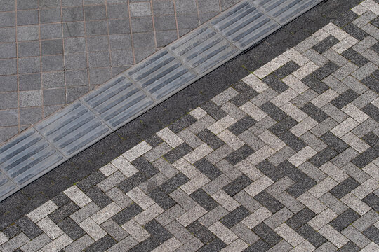 Detailed view of urban pavement with herringbone pattern, modern street design.