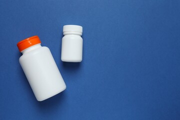 White bottles on blue background, top view