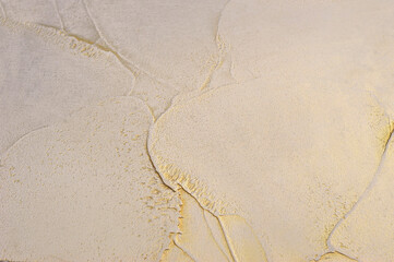 Decorative Venetian plaster with a texture molded with a spatula, plastic surface with gold, a play of light and shadow