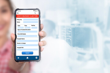 Someone holding smartphone showing health insurance claim form on screen.
