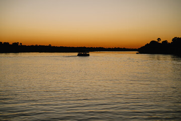 Silhouettes of boat at sunset on the Zambezi River in Zimbabwe