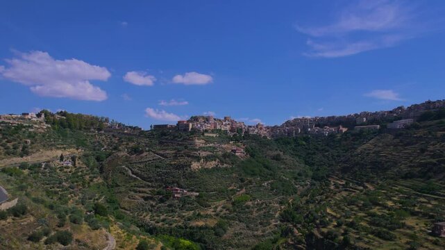 Aerial ascending view of the town of Centuripe in Sicily revealing Mount Etna