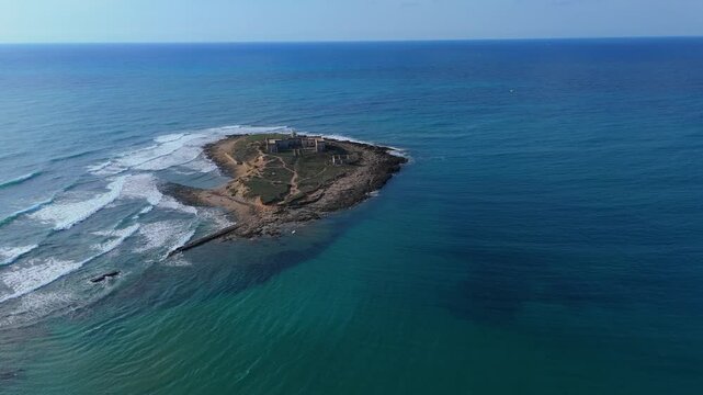 Aerial orbiting view of the small island Isola delle Correnti near Portopalo, the Southernmost point of Sicily