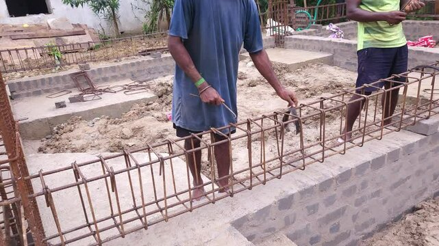 Construction workers using reinforced tmt steel bar with ease at the construction site, Reinforced bar (rebar). TMT steel rods tied together forming the core of concrete