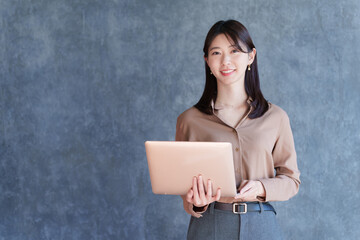 ノートパソコンを持つ女性ビジネスマン
