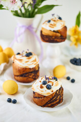 Traditional Easter cakes on festive table decorated with fresh flowers and colorful painted Easter eggs.