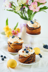 Traditional Easter cakes on festive table decorated with fresh flowers and colorful painted Easter eggs.