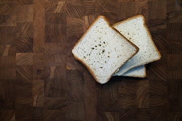sliced bread on a cutting board, wooden background
