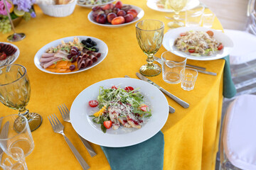 bright yellow festive banquet table with salads at the celebration