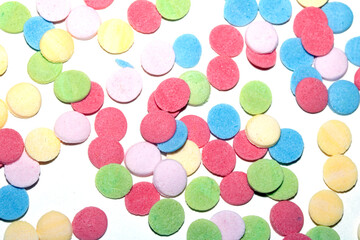 Close up of sugar paper confetti circle spots and colour dots on white background