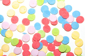 Close up of sugar paper confetti circle spots and colour dots on white background