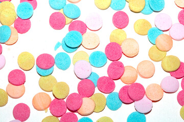 Close up of sugar paper confetti circle spots and colour dots on white background