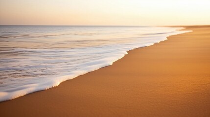 Obraz premium The ocean is calm and the beach is sandy. The sky is a beautiful orange color. The beach is empty and peaceful