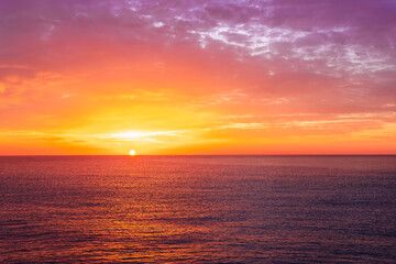 Fototapeta premium beautiful sunrise or sunset seascape with amazing calm sea water with waves and colorful amazing cloudy morning sky on background