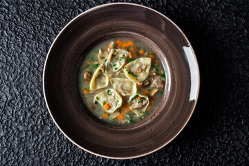 Mushroom Dumpling Soup in plate on black background. High quality photo.