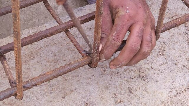Construction workers using reinforced tmt steel bar with ease at the construction site, Reinforced bar (rebar). TMT steel rods tied together forming the core of concrete