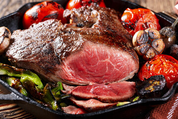 Large piece of grilled meat with vegetables, close-up
