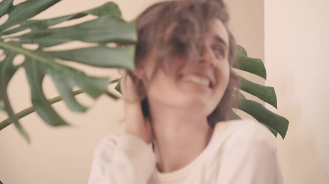 a calm contemplation to joyful playfulness as she interacts with large green leaves in a vibrant natural setting showcasing a journey of self-expression and connection