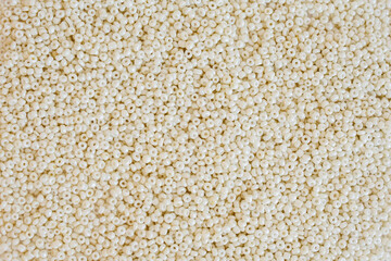 beige small glass beads close-up. Materials for jewelry production.