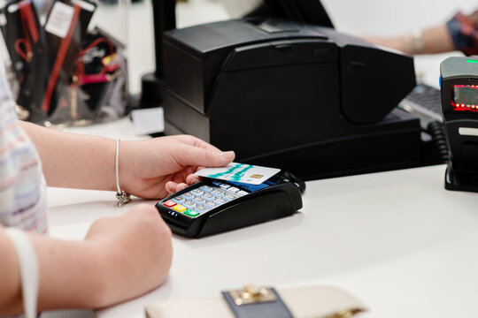 teen girl at the cash register, paying with debit card