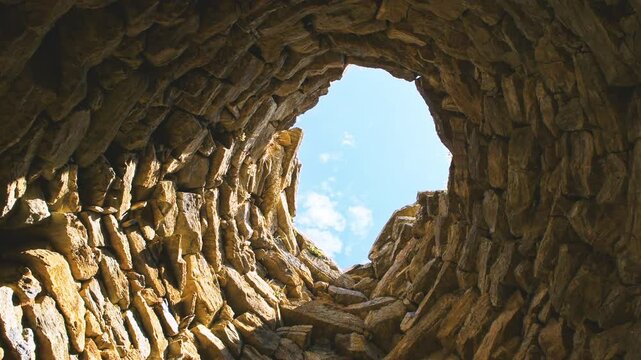 Nuraghe Su Nuraxi 'e Pauli in Seulo, Sardinia looking up low angle view on tower wall of rock stone material, ancient ruins in Italy