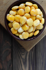 Lupin beans in a brown bowl on a wooden table. Italian food. Type of legumes. Healthy food concept. Vertical orientation. Selective focus. Copy space. Top view