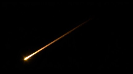 Dramatic fiery meteor streaks across a dark night sky, a celestial spectacle