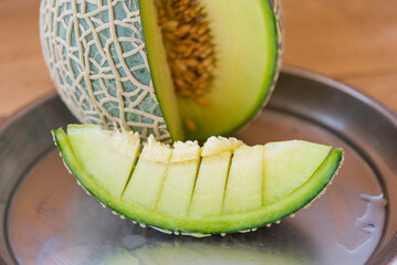 Fresh green melon on wood plate