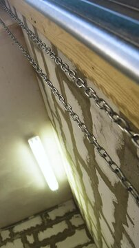 Big metal steal garage workroom chain hanging in the air Vertical Shot.