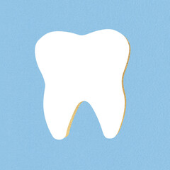 White tooth icon with golden shadow collage illustration. Grunge and noise effect applied. Retro vintage style. Soft blue background with copy space