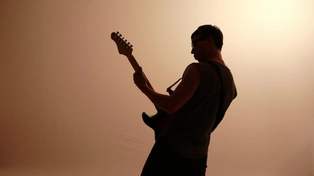 silhueta de homem guitarrista tocando guitarra eletrica 