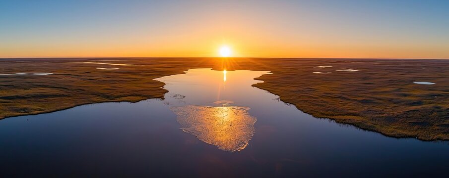 Iceberg melting idea. Breathtaking aerial view of sunset over calm river reflecting golden light.