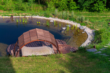 Pretty wooden pier at natural swimming pond or pool - NSP - purifying water without chemicals...
