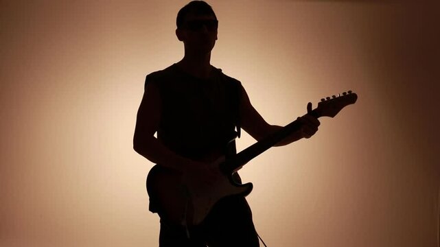 silhueta de homem guitarrista tocando guitarra eletrica 