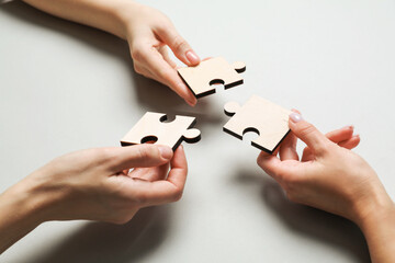 Business strategy and teamwork concept. Partners with different puzzle pieces on grey background,...