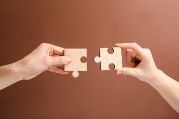 Business strategy and teamwork concept. Partners putting puzzle pieces together on brown...