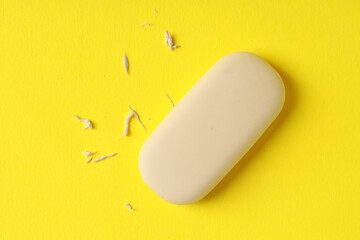 One eraser and scraps on yellow background, top view