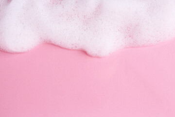 Sample of fluffy foam on pink background, top view. Space for text