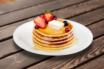 Fluffy sweet pancakes stacked with syrup