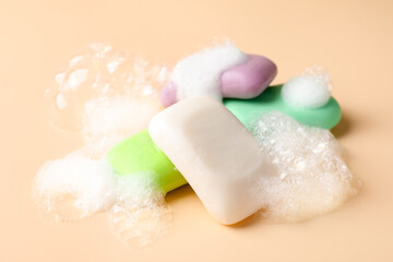 Soap bars with foam on beige background